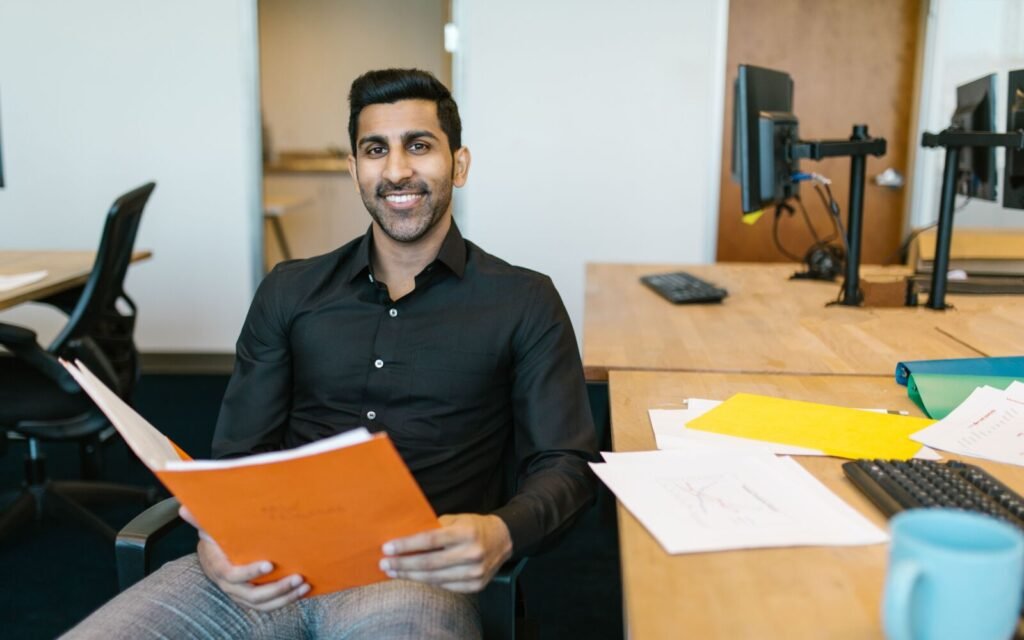 A small business owner reviewing plans at his desk